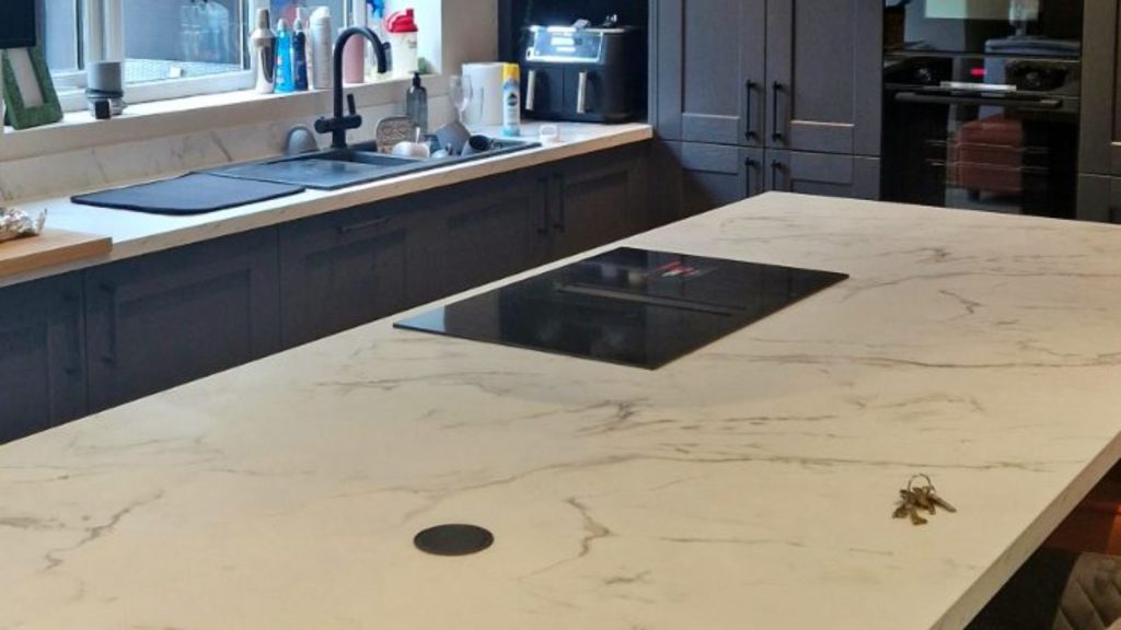 Marble island worktop with induction hob, pop-up socket and chrome pendant lights in a Rotherham kitchen fitted by MP Electrical