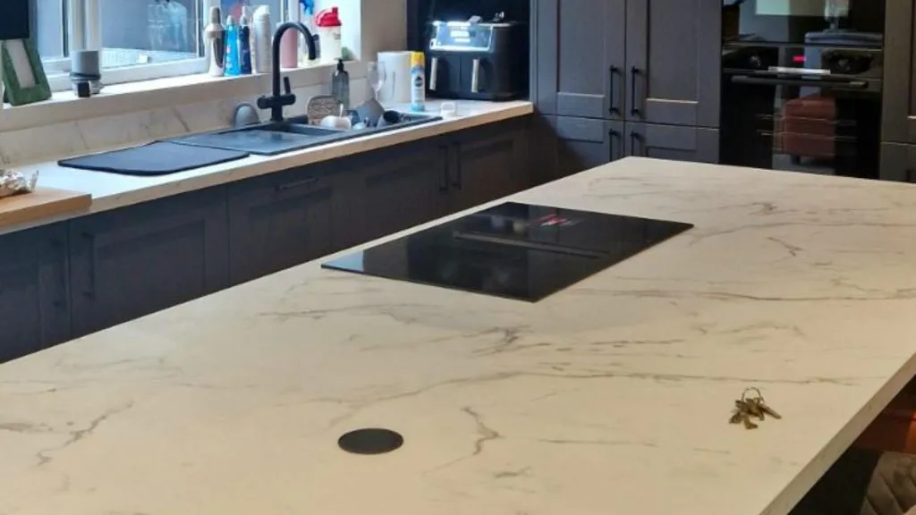 Marble island worktop with induction hob, pop-up socket and chrome pendant lights in a Rotherham kitchen fitted by MP Electrical