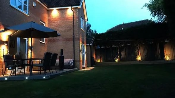 Rear garden patio at dusk with outdoor lighting fitted by a South Yorkshire electrician